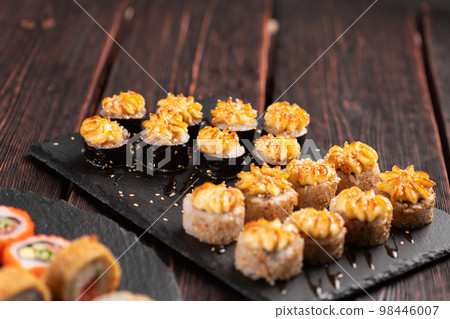 Japanese salmon sushi with spicy mayonnaise - Sushi menu norimaki and uramaki. Asian cuisine concept Japanese salmon sushi with spicy mayonnaise - Sushi menu norimaki and uramaki. Asian cuisine concept 98446007