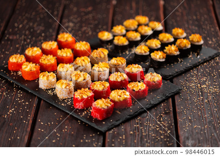 Japanese salmon sushi with spicy mayonnaise and tobiko caviar - Sushi menu norimaki and uramaki. Asian cuisine concept Japanese salmon sushi with spicy mayonnaise and tobiko caviar - Sushi menu norimaki and uramaki. Asian cuisine concept 98446015