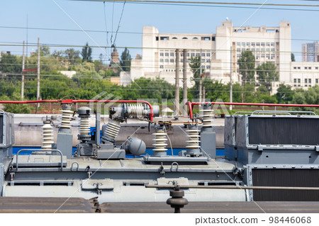 High-voltage insulators on the roof of a passenger train locomotive. 98446068