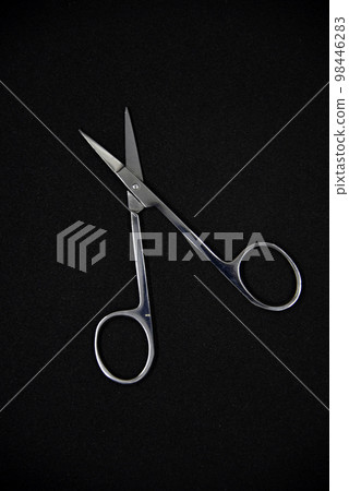 Manicure set on a black background. Scissors and nail tongs. Iron scissors and nail clippers. 98446283