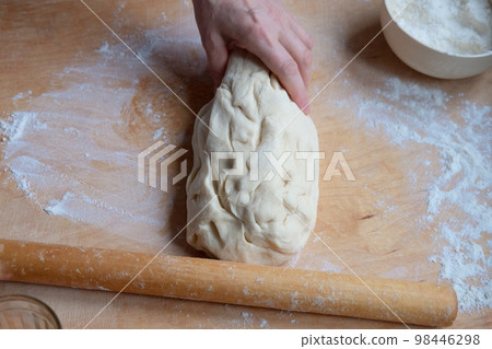 Working on an unfinished rolling pin test. Preparing pastries from dough Working on an unfinished rolling pin test. Preparing pastries from dough 98446298