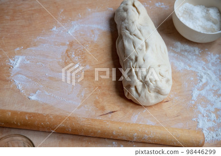 Working on an unfinished rolling pin test. Preparing pastries from dough Working on an unfinished rolling pin test. Preparing pastries from dough 98446299
