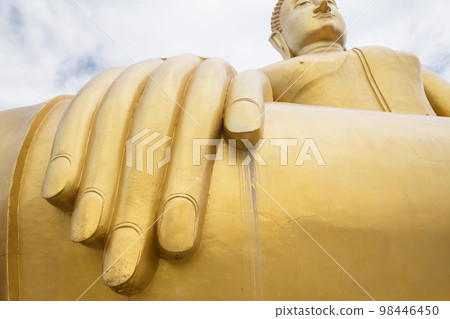 Fingers and hand of golden big buddha statue against sky Fingers and hand of golden big buddha statue against sky 98446450