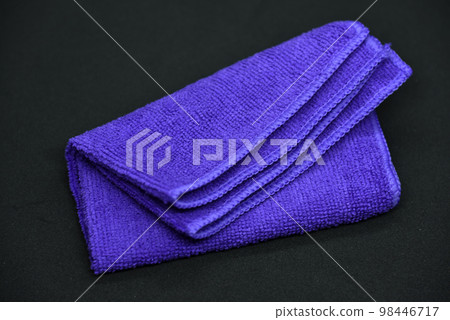 A cloth for wiping. Purple cloth on a black background. Towel. 98446717