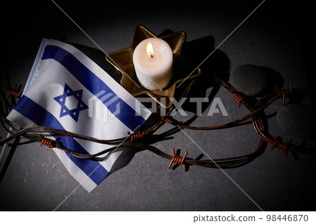 Burning candle, Barbed wire, flag of Israel on dark background. Holocaust memory day Burning candle, Barbed wire, flag of Israel on dark background. Holocaust memory day 98446870