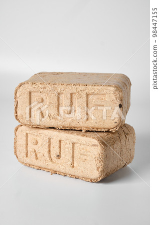 Two wooden briquettes (ruf type) on white background. Two wooden briquettes (ruf type) on white background. 98447155