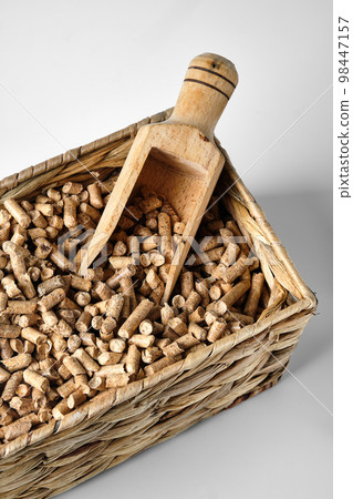 Hardwood Pellets used in pellet wood stoves in a wicker box and wooden scoop Hardwood Pellets used in pellet wood stoves in a wicker box and wooden scoop 98447157