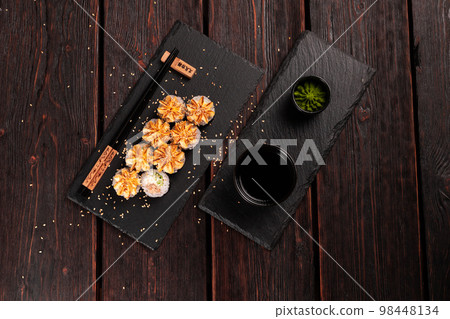 Maki sushi roll with eel and cucumber served on black board top view - Japanese food Maki sushi roll with eel and cucumber served on black board top view - Japanese food 98448134