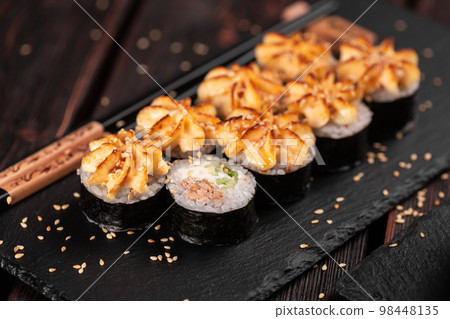 Maki sushi roll with eel and cucumber served on black board close-up - Japanese food Maki sushi roll with eel and cucumber served on black board close-up - Japanese food 98448135