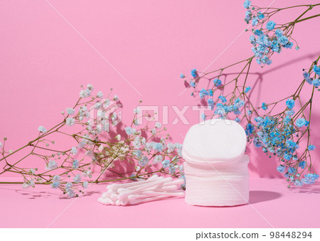 Round cotton cosmetic pads and cotton buds on a pink background Round cotton cosmetic pads and cotton buds on a pink background 98448294