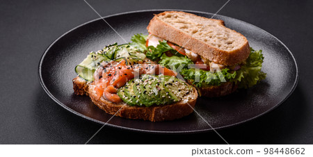 Fresh tasty sandwich with salmon, avocado and sesame and flax seeds Fresh tasty sandwich with salmon, avocado and sesame and flax seeds 98448662