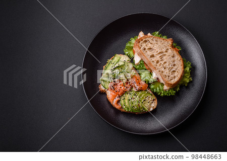 Fresh tasty sandwich with salmon, avocado and sesame and flax seeds 98448663