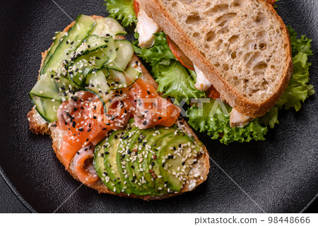 Fresh tasty sandwich with salmon, avocado and sesame and flax seeds Fresh tasty sandwich with salmon, avocado and sesame and flax seeds 98448666