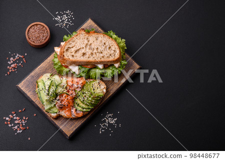 Fresh tasty sandwich with salmon, avocado and sesame and flax seeds Fresh tasty sandwich with salmon, avocado and sesame and flax seeds 98448677