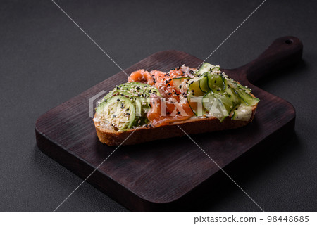 Fresh tasty sandwich with salmon, avocado and sesame and flax seeds 98448685