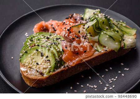 Fresh tasty sandwich with salmon, avocado and sesame and flax seeds Fresh tasty sandwich with salmon, avocado and sesame and flax seeds 98448690