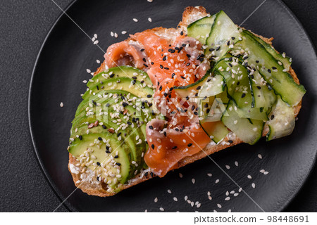 Fresh tasty sandwich with salmon, avocado and sesame and flax seeds Fresh tasty sandwich with salmon, avocado and sesame and flax seeds 98448691