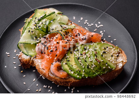 Fresh tasty sandwich with salmon, avocado and sesame and flax seeds Fresh tasty sandwich with salmon, avocado and sesame and flax seeds 98448692