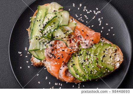 Fresh tasty sandwich with salmon, avocado and sesame and flax seeds Fresh tasty sandwich with salmon, avocado and sesame and flax seeds 98448693
