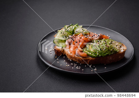 Fresh tasty sandwich with salmon, avocado and sesame and flax seeds Fresh tasty sandwich with salmon, avocado and sesame and flax seeds 98448694