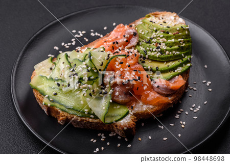 Fresh tasty sandwich with salmon, avocado and sesame and flax seeds Fresh tasty sandwich with salmon, avocado and sesame and flax seeds 98448698