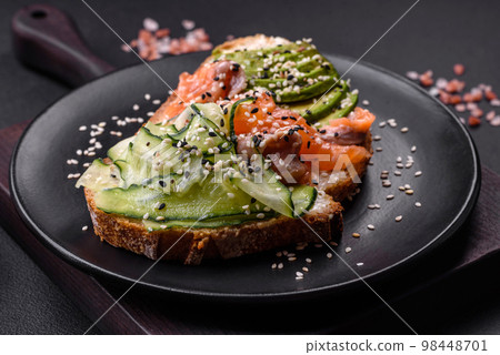 Fresh tasty sandwich with salmon, avocado and sesame and flax seeds 98448701