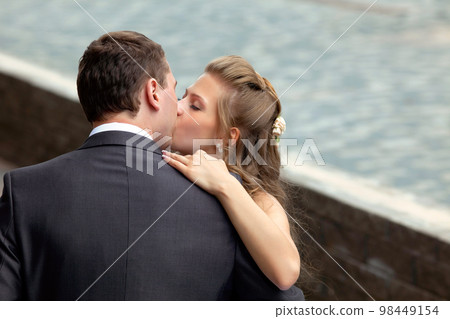 young wedding couple kissing young wedding couple kissing 98449154
