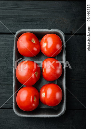 Red ripe tomatoe, on black wooden table Red ripe tomatoe, on black wooden table 98449213