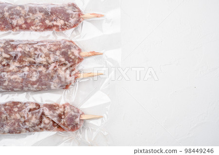 Turkish uncooked shish minced meat kofta in vacuum pack, on white stone table background, top view flat lay, with copy space for text Turkish uncooked shish minced meat kofta in vacuum pack, on white stone table background, top view flat lay, with copy space for text 98449246
