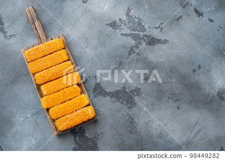 Crispy Fish fingers, on wooden cutting board, on gray background, top view flat lay , with copyspace and space for text Crispy Fish fingers, on wooden cutting board, on gray background, top view flat lay , with copyspace and space for text 98449282