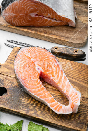 Raw salmon fish fillet with fresh herbs, on white stone table background 98449350