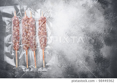 Packed kebab from lamb or mutton meat, on gray stone table background, top view flat lay, with copy space for text Packed kebab from lamb or mutton meat, on gray stone table background, top view flat lay, with copy space for text 98449362