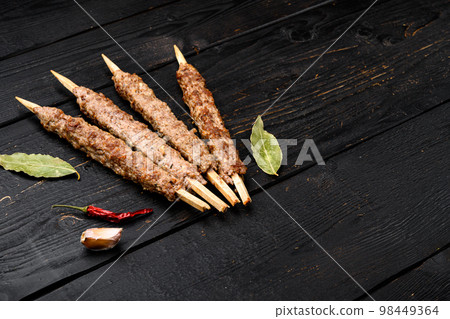 Minced and shaped lamb mutton kebabs, on black wooden table background, with copy space for text Minced and shaped lamb mutton kebabs, on black wooden table background, with copy space for text 98449364