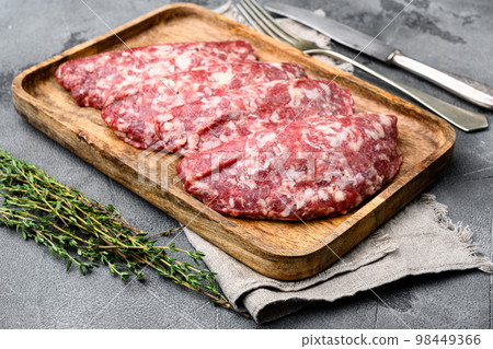 Raw Minced Meat Cutlets. Fresh Minced Beef Pork Steak Burgers, on gray stone table background Raw Minced Meat Cutlets. Fresh Minced Beef Pork Steak Burgers, on gray stone table background 98449366