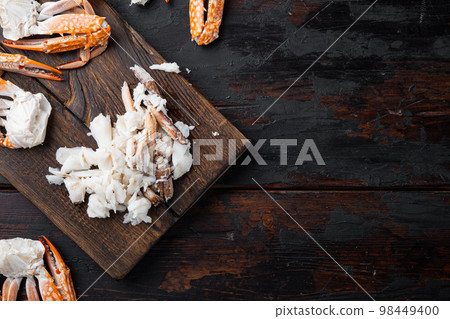 Thai blue swimming crab boiled meat parts, on wooden cutting board, on dark wooden background, top view flat lay , with copyspace and space for text Thai blue swimming crab boiled meat parts, on wooden cutting board, on dark wooden background, top view flat lay , with copyspace and space for text 98449400