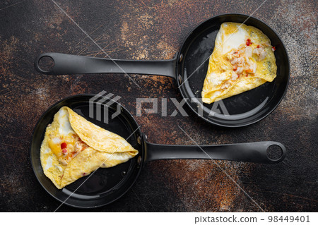 Fried breakfast omelette with crab meat and cheese, on frying iron pan, on old dark rustic background, top view flat lay Fried breakfast omelette with crab meat and cheese, on frying iron pan, on old dark rustic background, top view flat lay 98449401