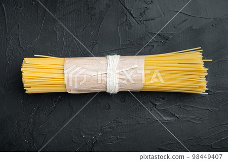Spaghetti Italian Traditional Cuisine, dry and uncooked, on black background, top view flat lay Spaghetti Italian Traditional Cuisine, dry and uncooked, on black background, top view flat lay 98449407