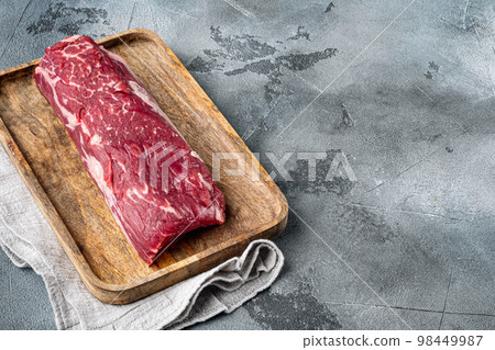 Fresh Raw Beef steak Mignon whole cut, on gray stone background, with copy space for text 98449987