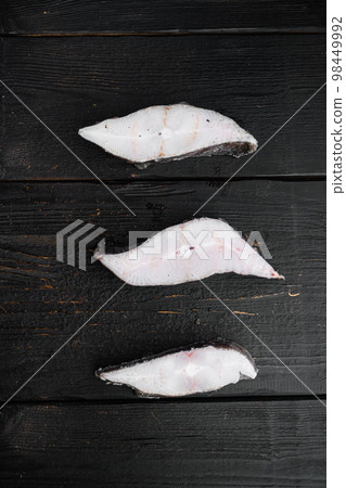 Frozen fish cut, on black wooden table background, top view flat lay 98449992