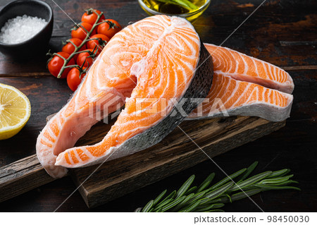 Slice of red fish salmon with herbs, on old wooden table 98450030