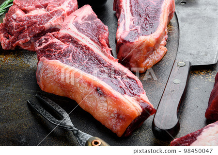 T bone steak. Organic raw Tbon beef marbled meat, on old dark rustic background T bone steak. Organic raw Tbon beef marbled meat, on old dark rustic background 98450047