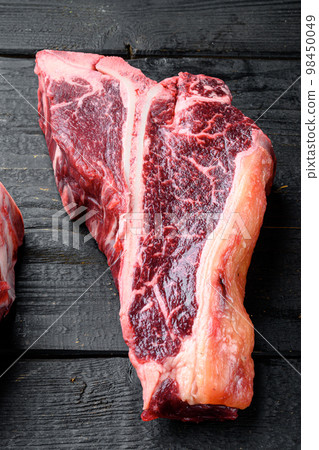 Raw fresh beef T bone steak, on black wooden table background Raw fresh beef T bone steak, on black wooden table background 98450049