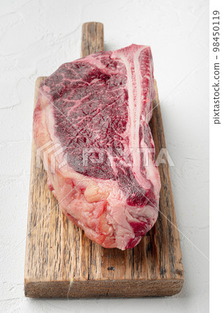 Raw fresh meat dry aged Club Steak, on white stone  background 98450119
