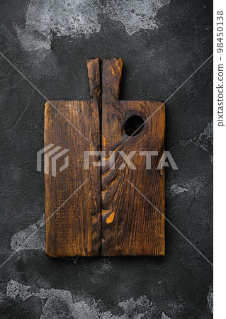 Scratched chopping board, on black dark stone table background, top view flat lay , with copy space for text or your product 98450138