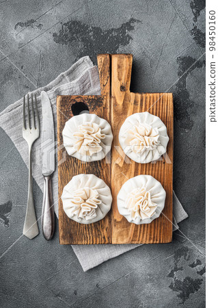 Khinkali Dumplings with beef and lamb meat, on gray stone background, top view flat lay Khinkali Dumplings with beef and lamb meat, on gray stone background, top view flat lay 98450160