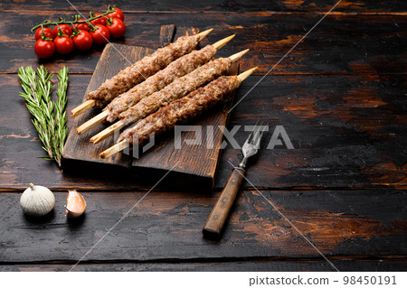 Mutton kebab shish skewers, on serving board, on old dark  wooden table background, with copy space for text Mutton kebab shish skewers, on serving board, on old dark  wooden table background, with copy space for text 98450191