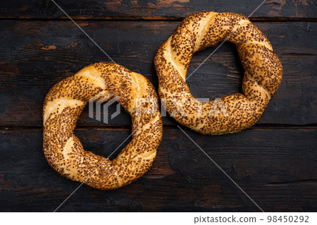 Bagel Simit with sesame, traditional pastry of Turkey , on old dark wooden table background, top view flat lay, with copy space for text Bagel Simit with sesame, traditional pastry of Turkey , on old dark wooden table background, top view flat lay, with copy space for text 98450292