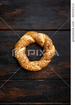 Simit Turkish fast food bagel , on old dark wooden table background, top view flat lay, with copy space for text Simit Turkish fast food bagel , on old dark wooden table background, top view flat lay, with copy space for text 98450313