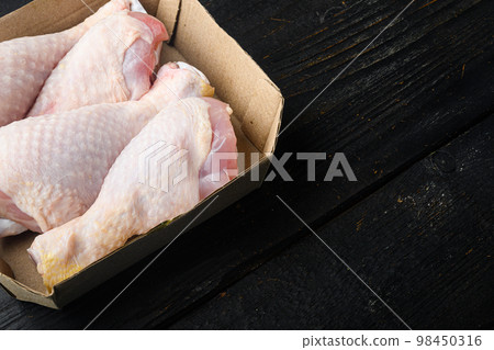 Chicken meat package, in paper Pack, on black wooden table background, with copy space for text Chicken meat package, in paper Pack, on black wooden table background, with copy space for text 98450316