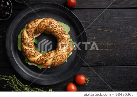 Traditional Turkish bagel simit, breakfast, on black wooden table background, top view flat lay, with copy space for text 98450363